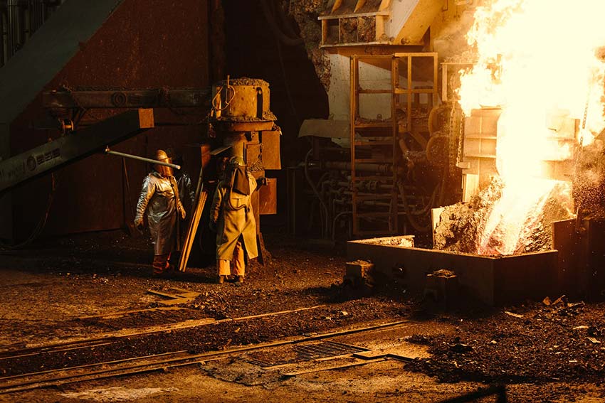 A worker stands beside the furnace door. Ricky Rhodes